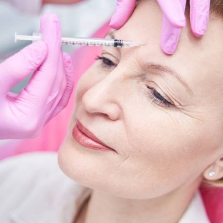 Professional medical worker using sterile syringe while anti-age injection